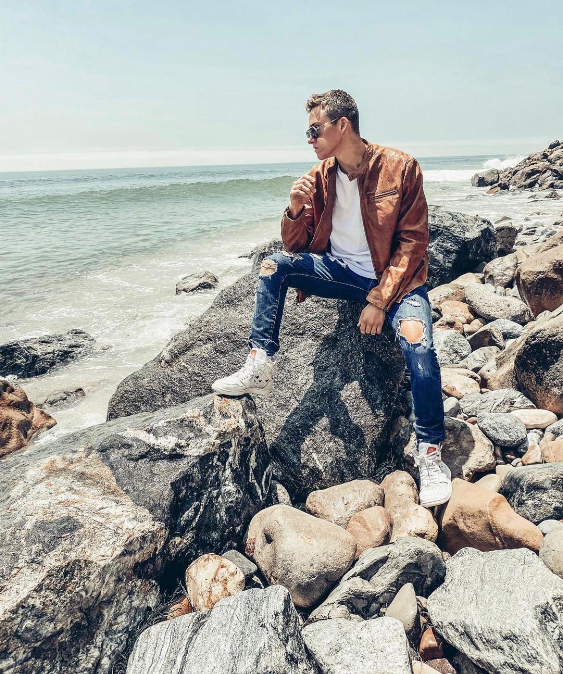 Truitt Battin rocking a John Varvatos jacket as he relaxes by the beach