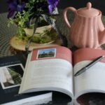 A notebook with a pen and flowers on it